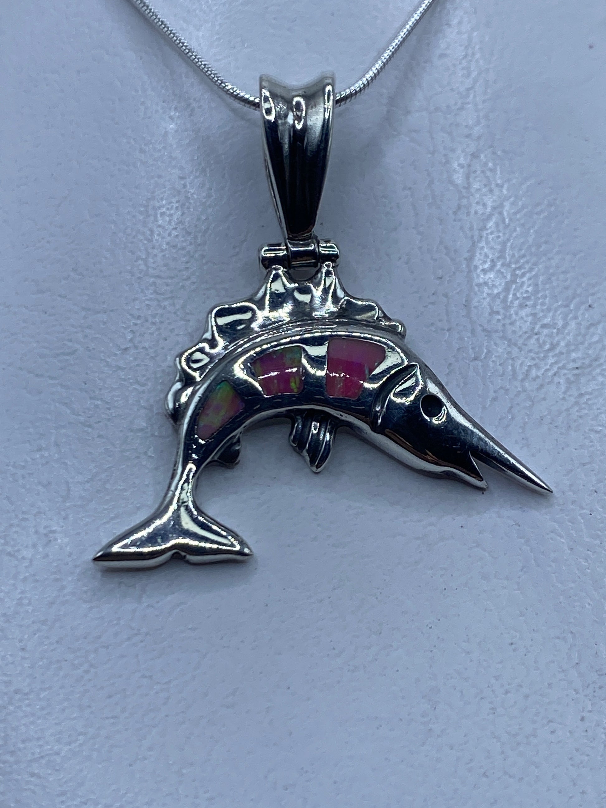 Dije delfín en plata .950 con ópalo de fuego rosa, visto de frente sobre cadena de plata