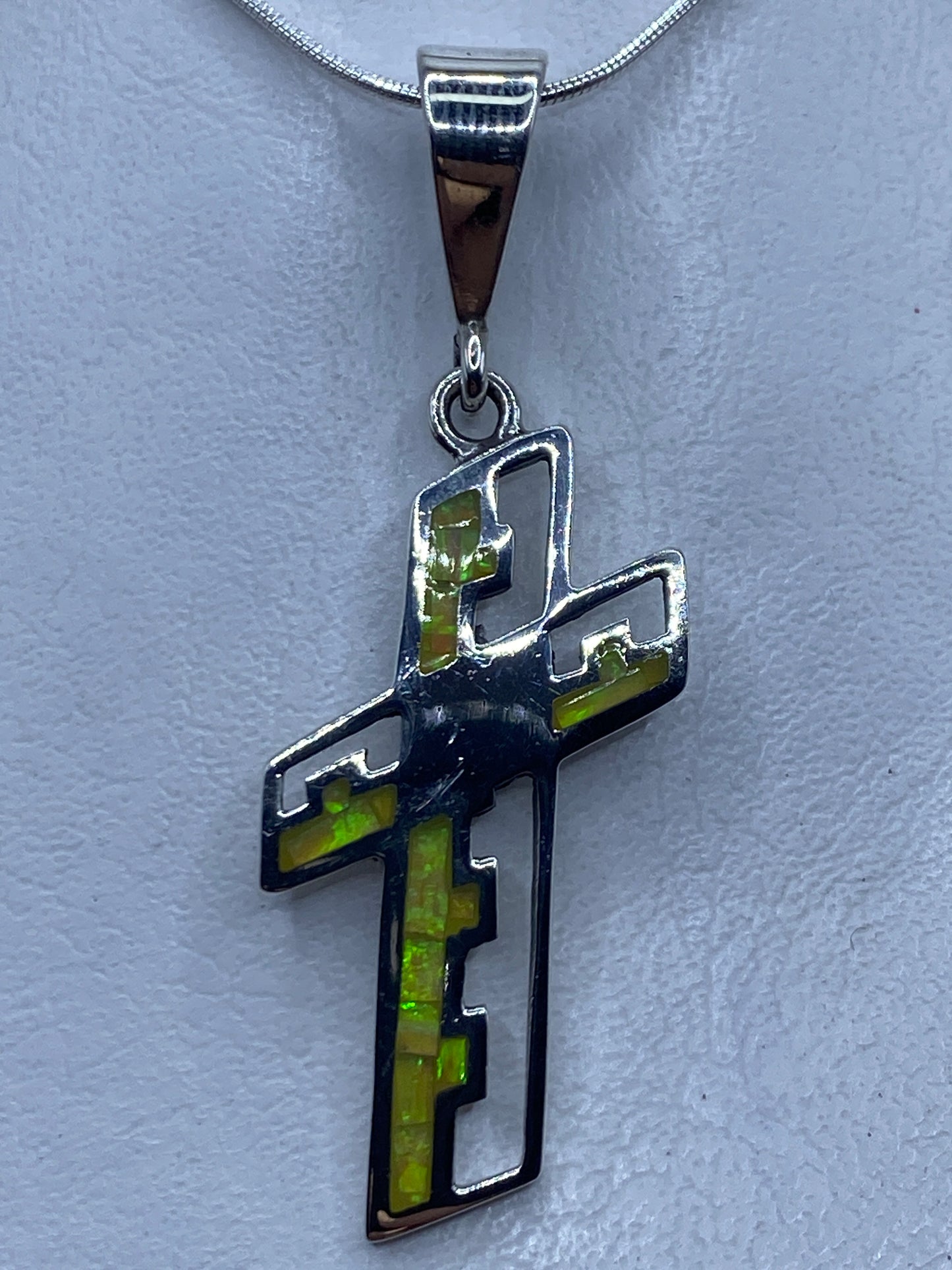 Dije cruz de plata .950 con Ópalo de Fuego engastado, 6 cm de largo, colgando de cadena plateada