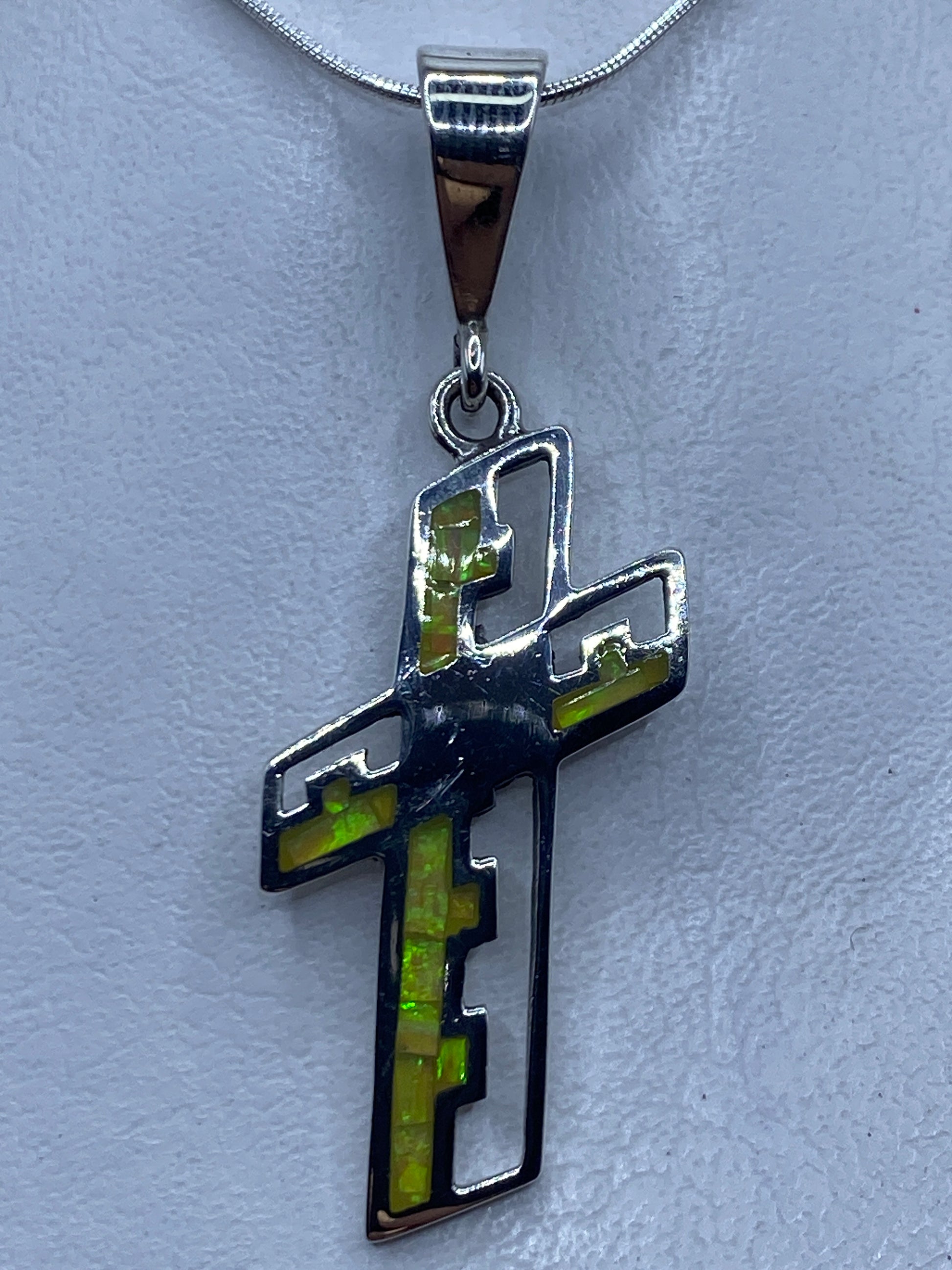 Dije cruz de plata .950 con Ópalo de Fuego engastado, 6 cm de largo, colgando de cadena plateada