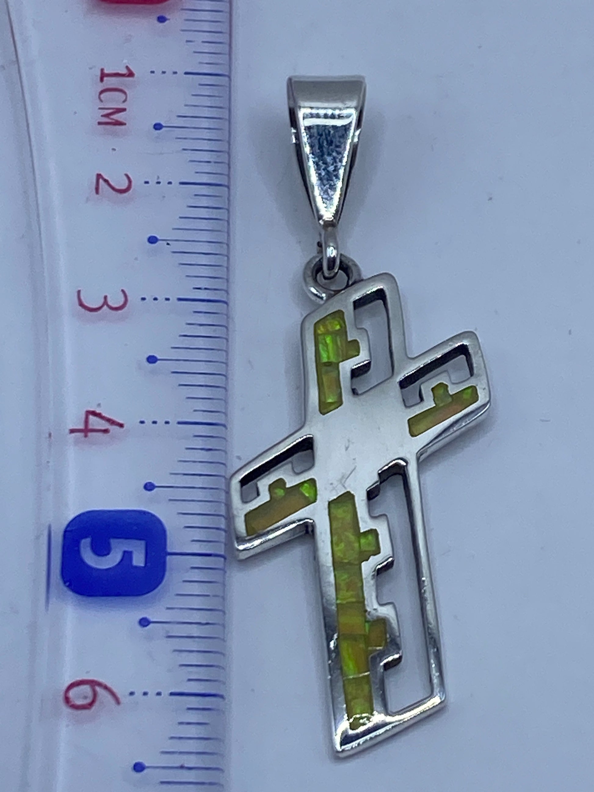 Medida de la cruz junto a regla, 6 cm de largo total