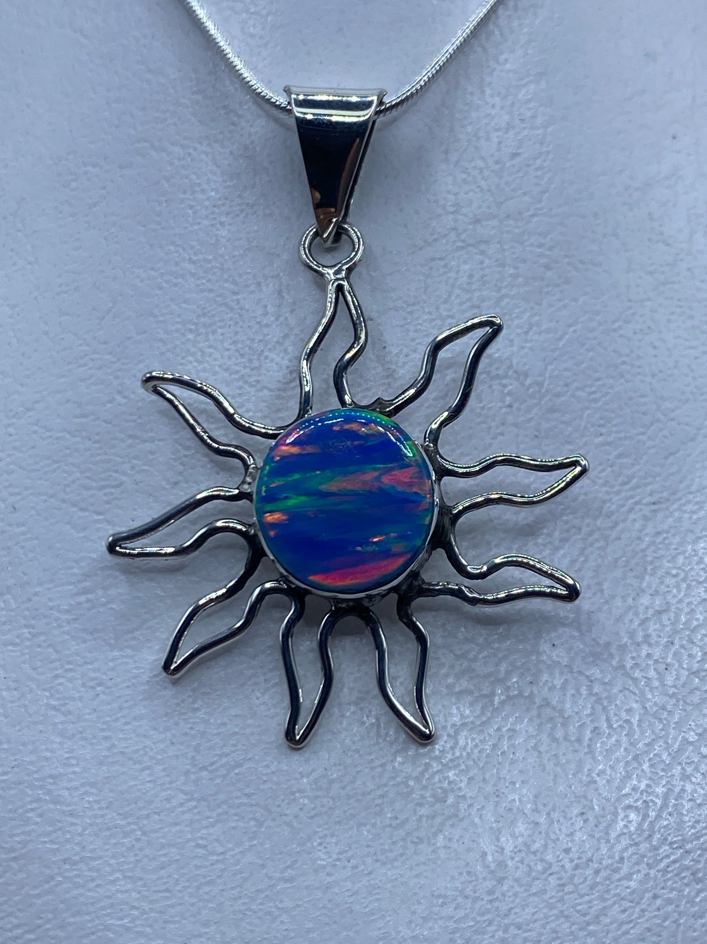 Dije sol de plata .950 con ópalo de fuego azul engastado, rayos ondulantes de plata artesanal
