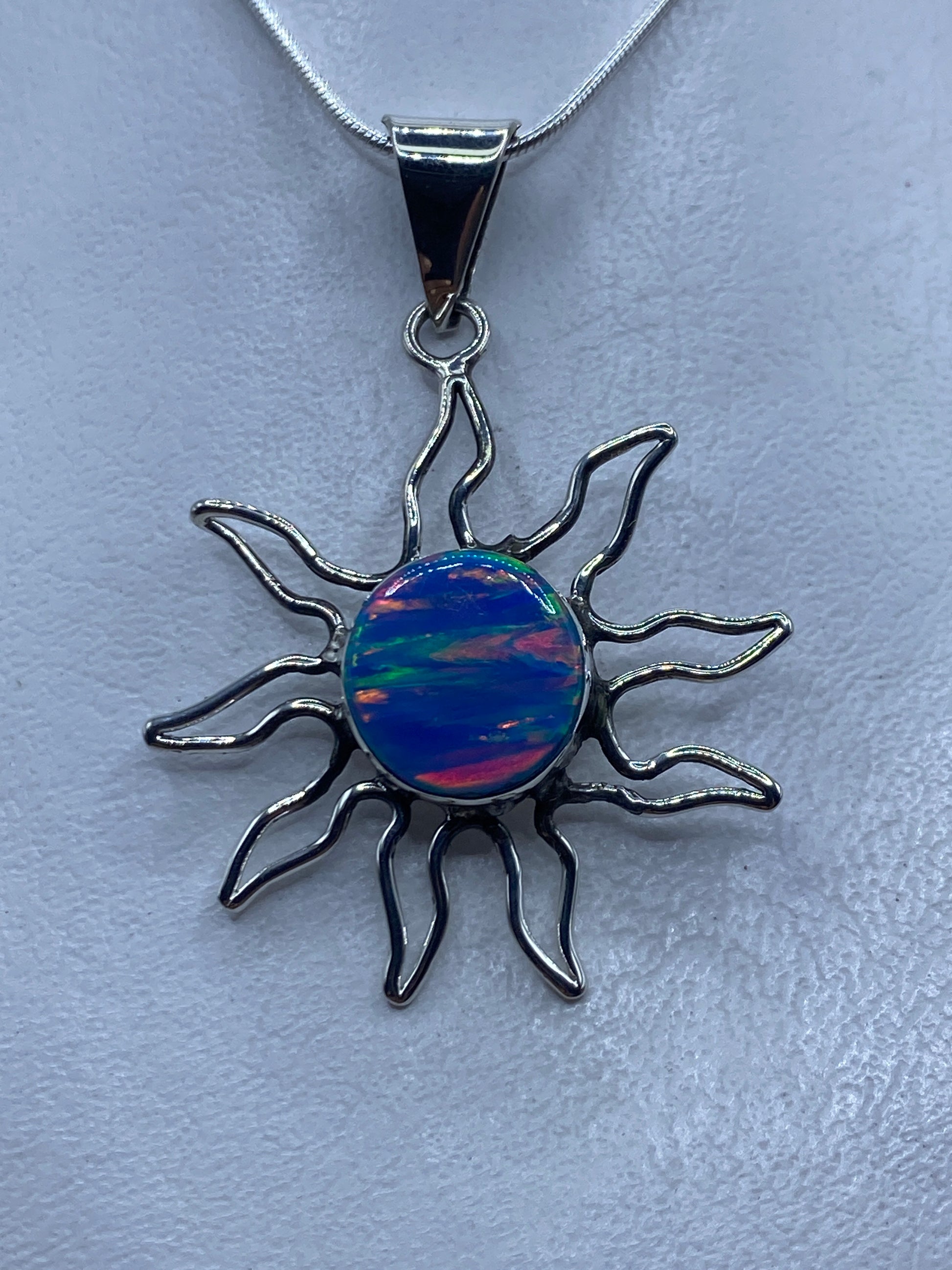 Dije sol de plata .950 con ópalo de fuego azul engastado, rayos ondulantes de plata artesanal