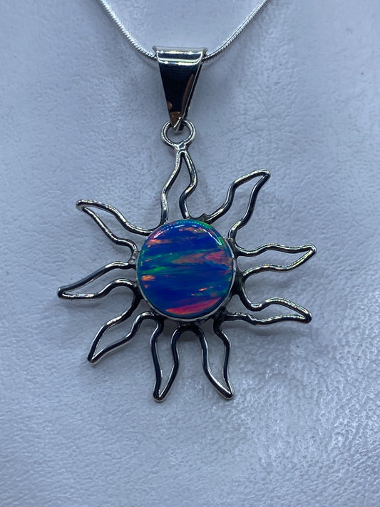 Dije sol de plata .950 con ópalo de fuego azul engastado, rayos ondulantes de plata artesanal