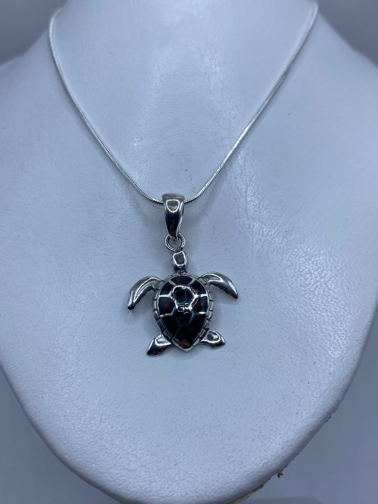 Detalle del diseño de la tortuga con ópalo de fuego: aletas extendidas y caparazón texturado