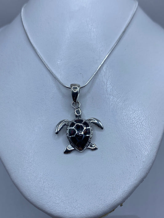 Detalle del diseño de la tortuga con ópalo de fuego: aletas extendidas y caparazón texturado