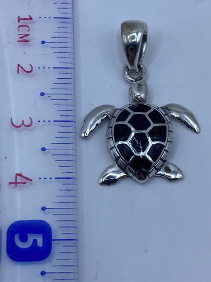 Tortuga marina en plata pulida brillo, fotografía de perfil mostrando el relieve del diseño