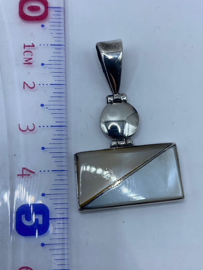 Dije prehispánico en cadena de plata sobre pecho