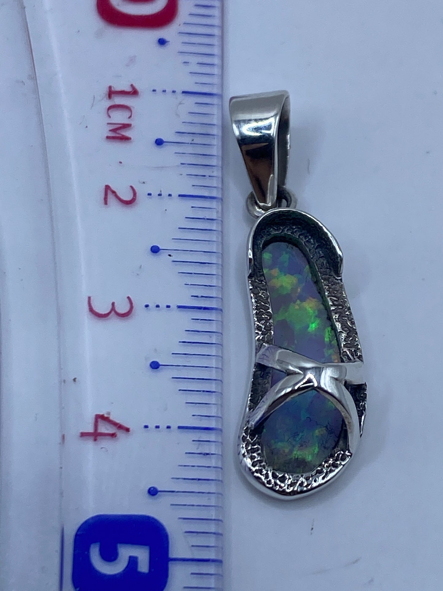 Dije de plata pesado en balanza de precisión, 2.4 gramos