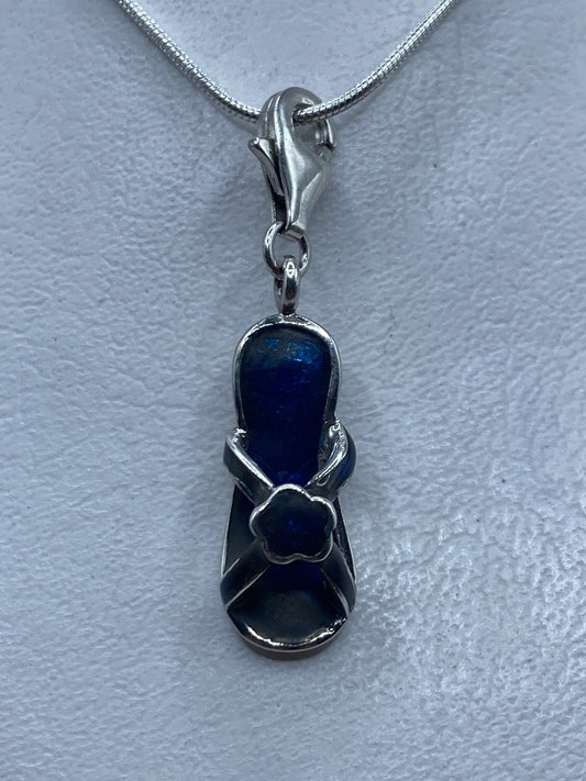 Dije de plata .925 con piedra azul engastada, colgando de cadena plateada