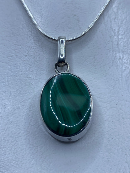 Dije de plata .950 con malaquita verde colgando de cadena de plata