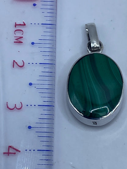 Dije de 3.6 cm de largo junto a regla de medida, con sello .950 visible en la plata