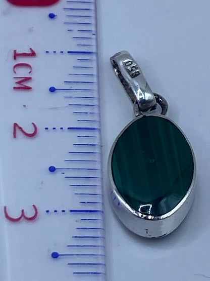 Escala de medición mostrando el dije de 3.3 cm de largo en comparación con una regla