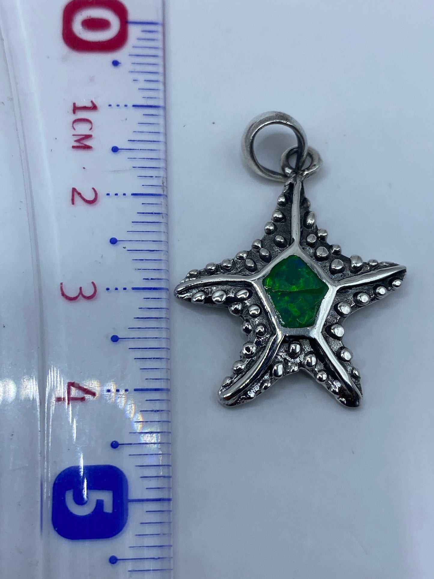 Reverso del dije mostrando Quinto .950 y acabado texturado en plata pura