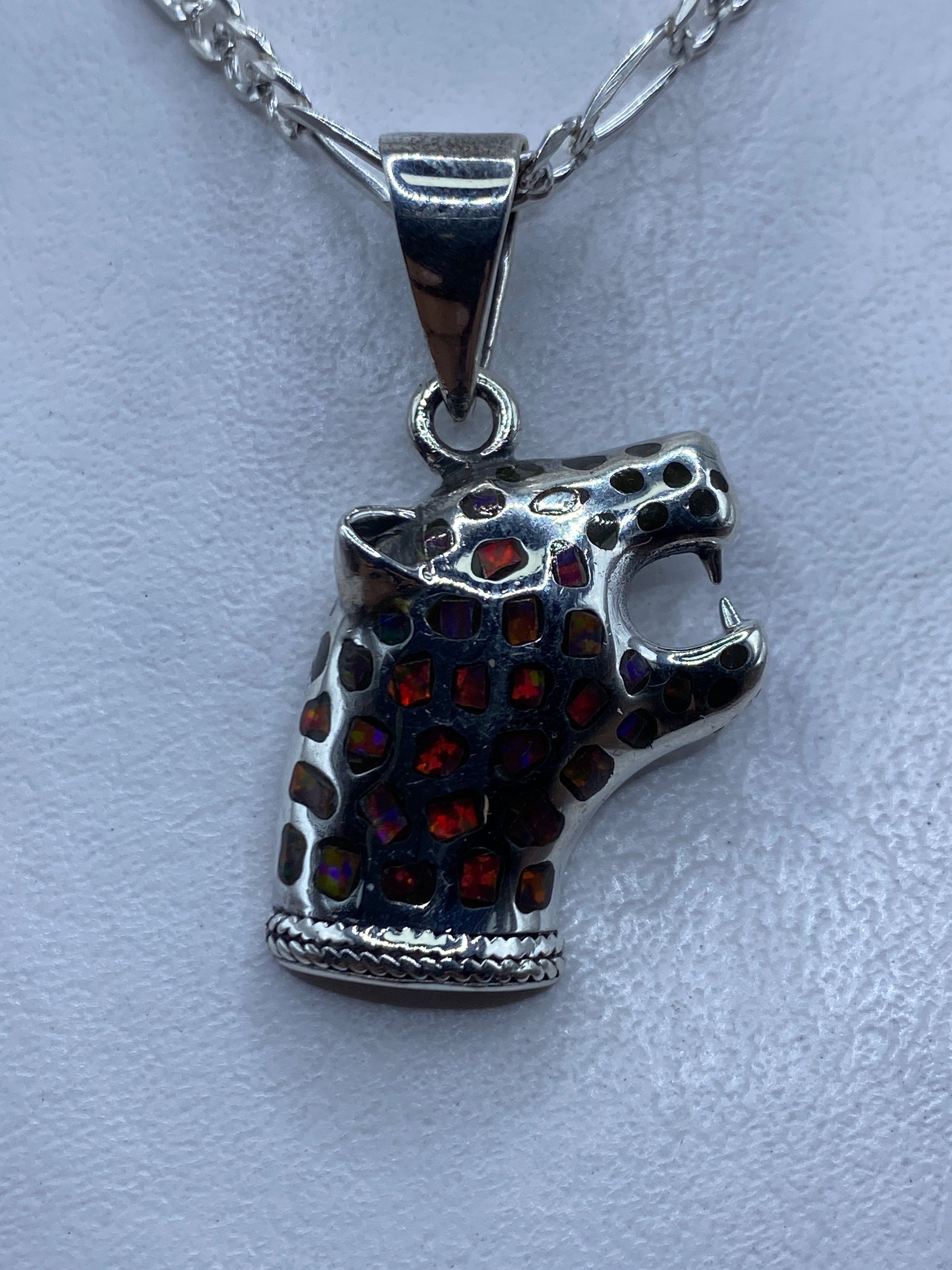 Dije de plata con ópalo de fuego multicolor, diseño prehispánico, colgando de cadena figaro