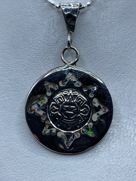 Dije de plata con ópalo de fuego multicolor en diseño de sol prehispánico azteca