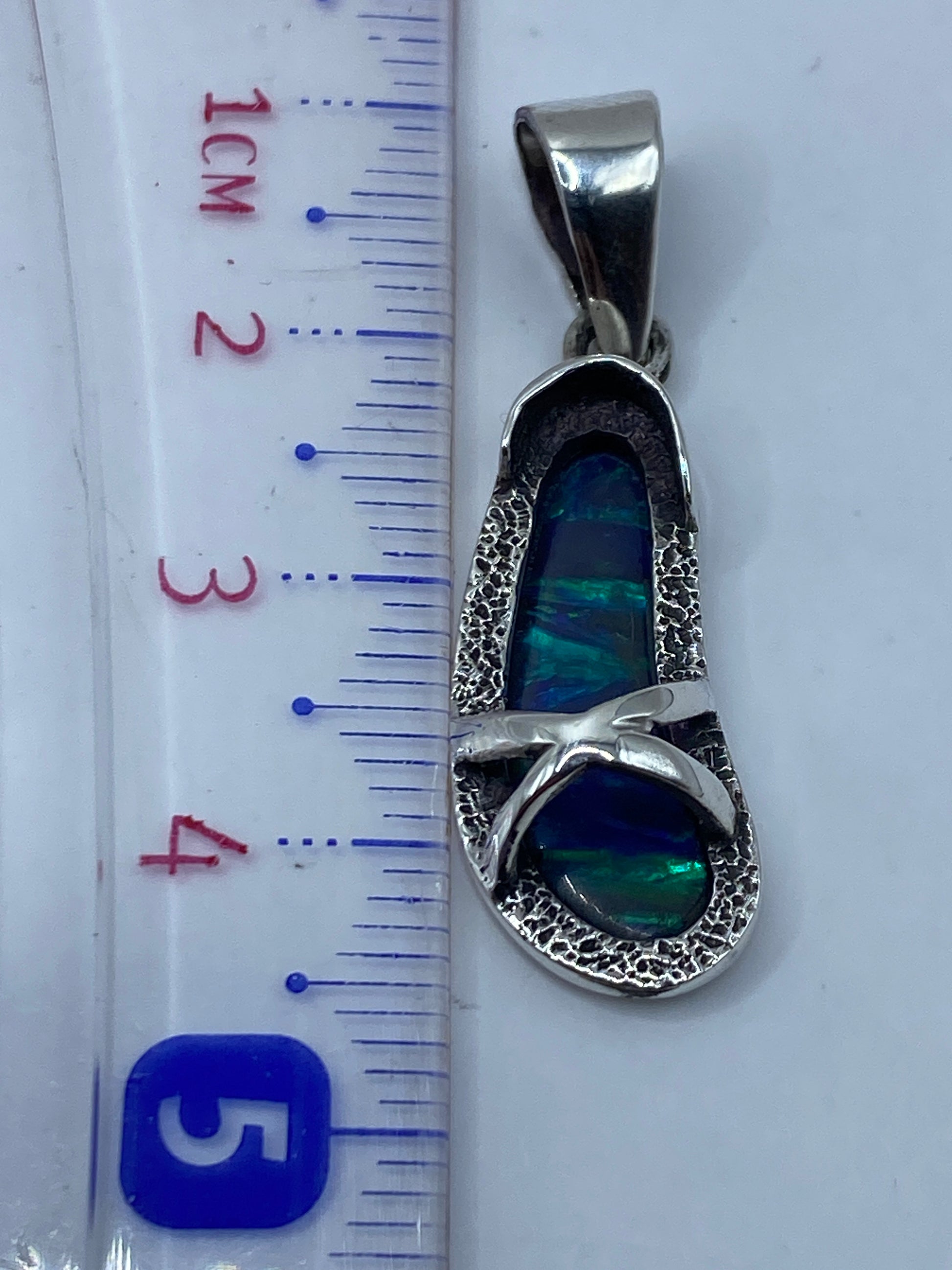 Medición en escala: dije de 4.3 cm sobre regla, peso 2.8 gramos