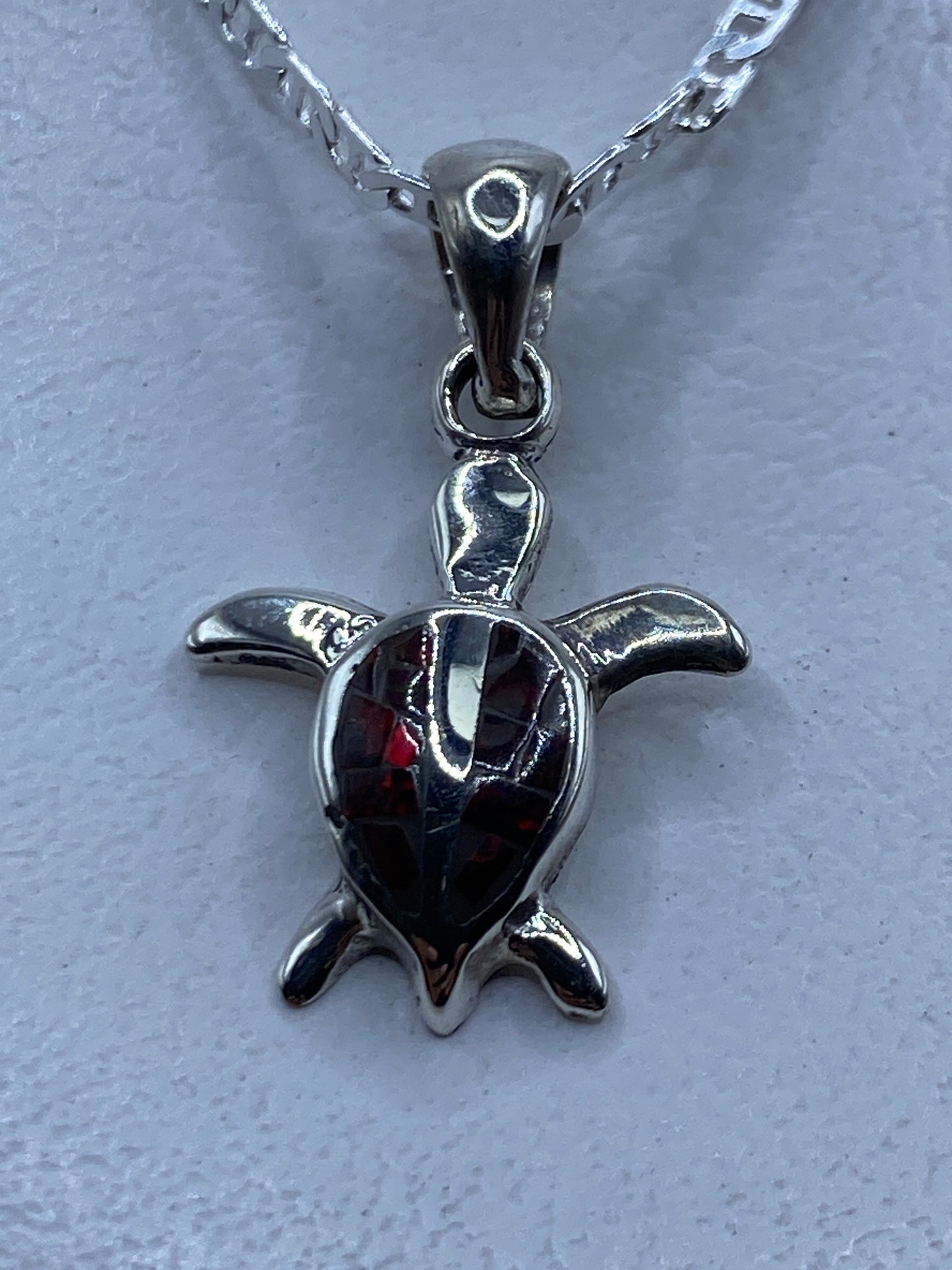 Dije de plata .950 en forma de tortuga con Ópalo de Fuego rojo engastado a mano, colgando de una cadena plateada