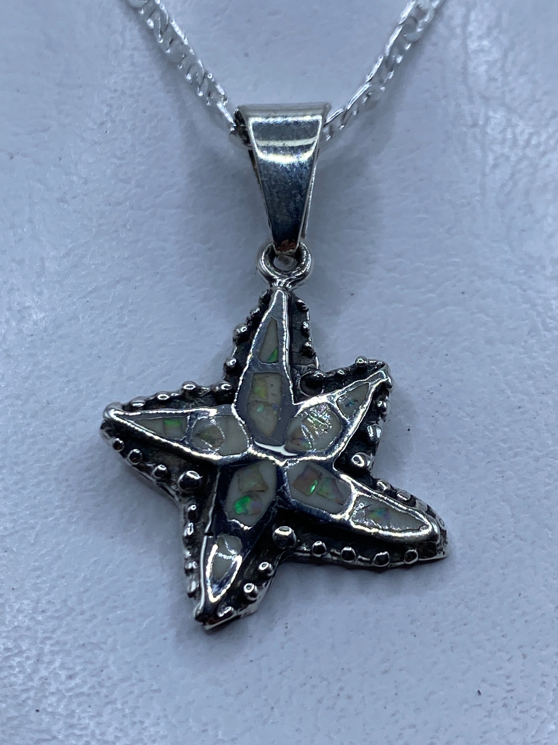 Dije de plata .950 en forma de estrella marina con ópalo de fuego multicolor, colgante sin cadena