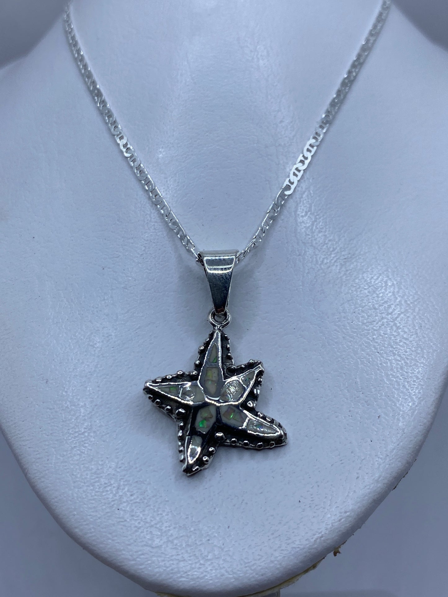 Dije de estrella marina midiendo 4.2 cm junto a regla, mostrando tamaño real