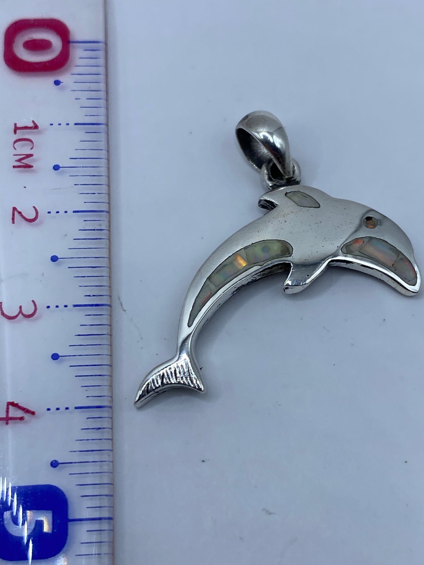 Dije de plata .950 junto a regla de medidas mostrando largo de 4 cm