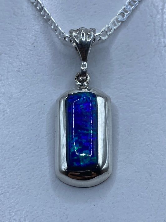 Dije de plata con ópalo de fuego azul colgando de cadena plateada