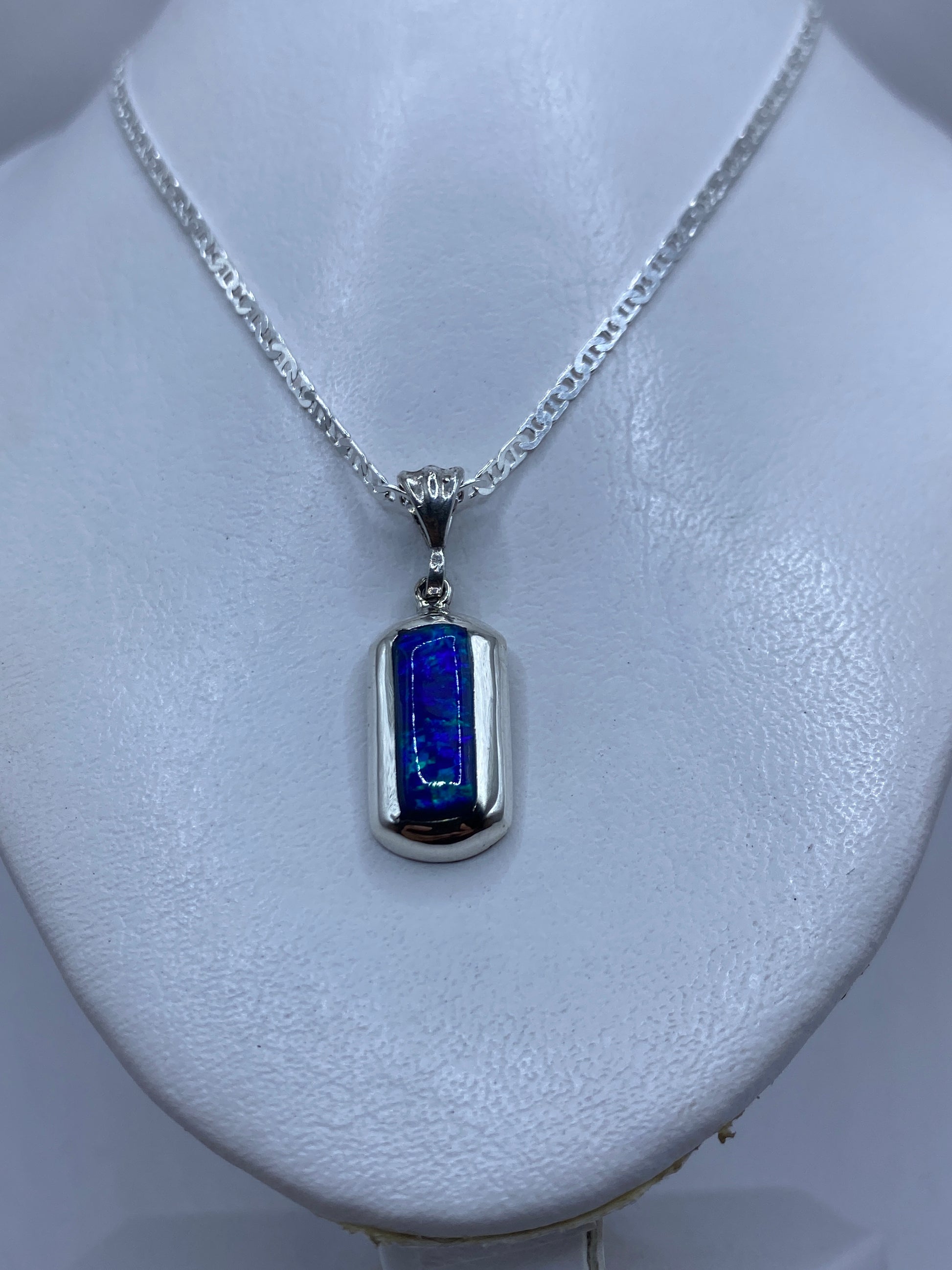Primer plano del dije mostrando el ópalo azul engastado en plata .925