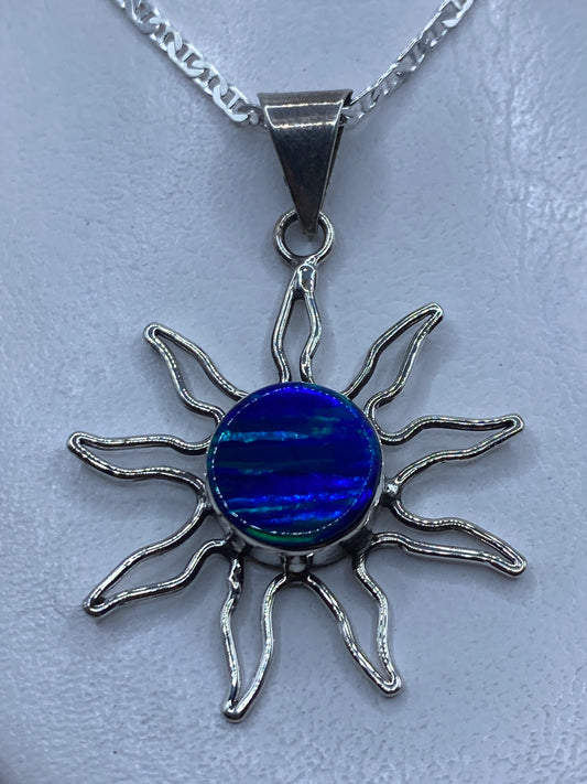 Dije sol de plata .950 con opalo de fuego azul en el centro, rayos de plata trabajada a mano