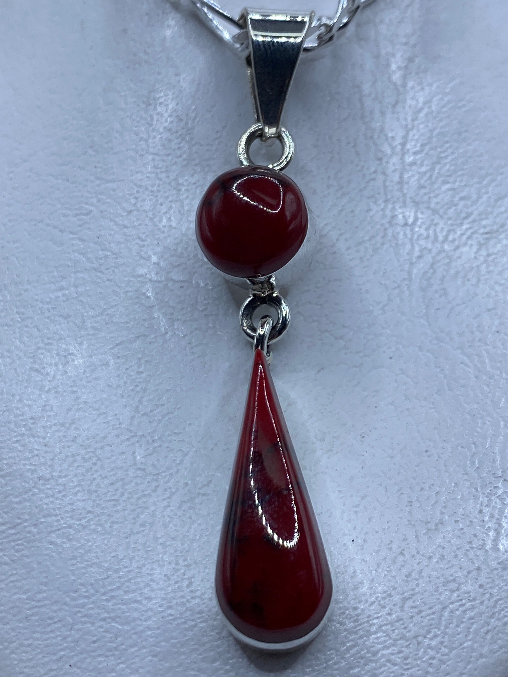 Dije de plata con coral rojo engastado, largo 6.3 cm, colgando de cadena plateada