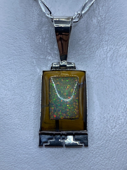 Dije de plata prehispánico de 4.7 cm con piedra engastada y motivos grabados, colgando en cadena de plata
