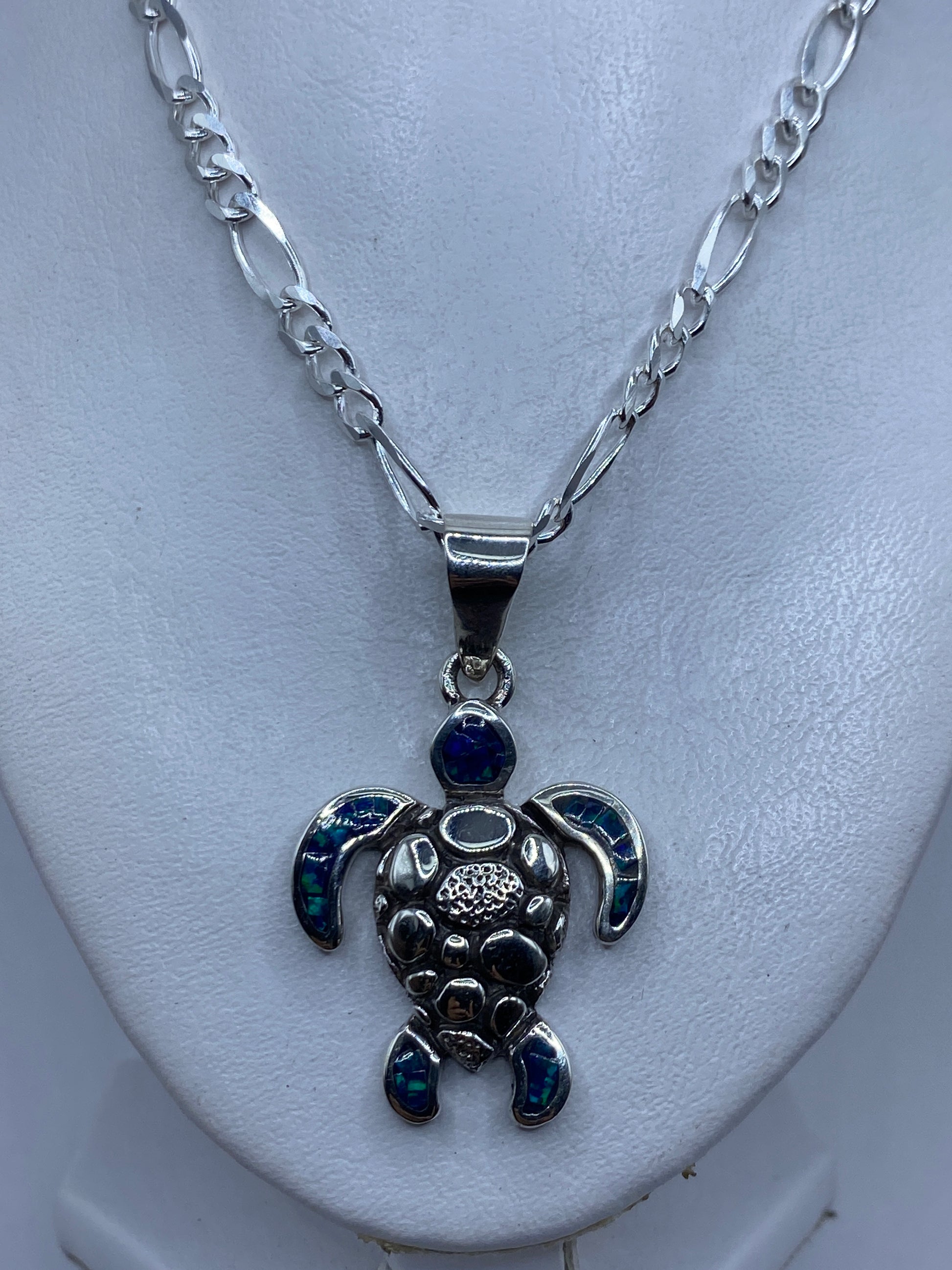Dije tortuga de 5.3 cm sobre regla, detalle del engaste artesanal de ópalo