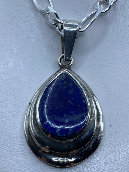 Dije de plata .925 con piedra azul engastada, colgado de una cadena plateada