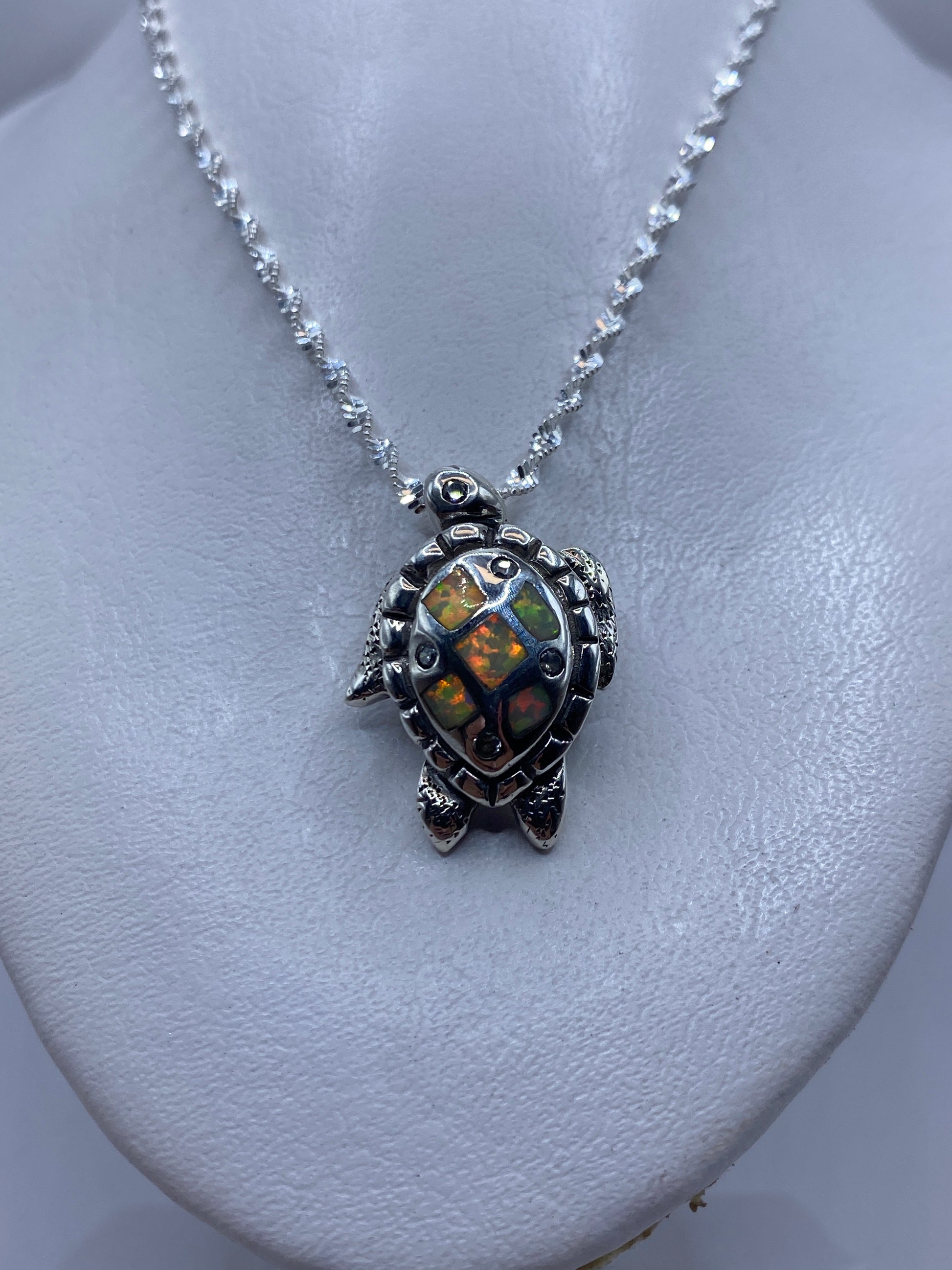 Dije tortuga visto de cerca mostrando el engaste de la piedra a mano