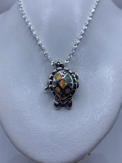 Dije tortuga visto de cerca mostrando el engaste de la piedra a mano