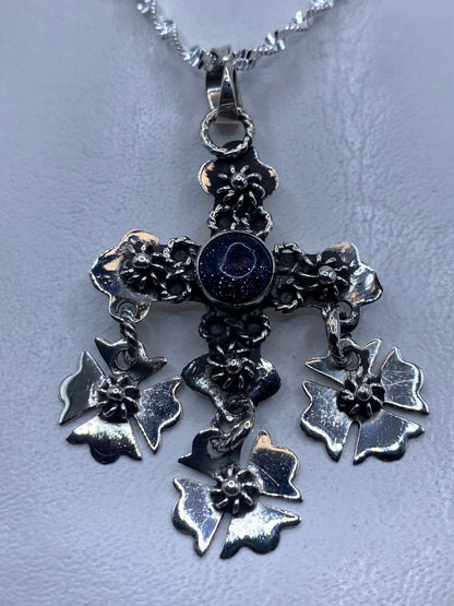 Dije cruz floral de plata .925 con piedra morada colgando en cadena