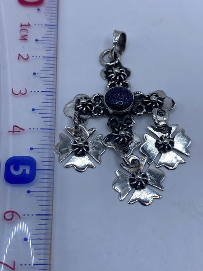 Dije cruz de plata Taxco sobre regla, midiendo 5.7 cm de largo