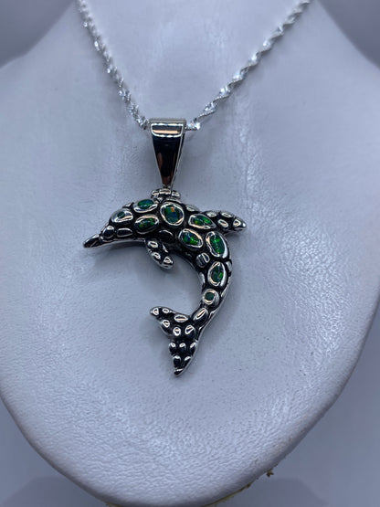 Detalle de la incrustación de piedra del ópalo en el delfín de plata