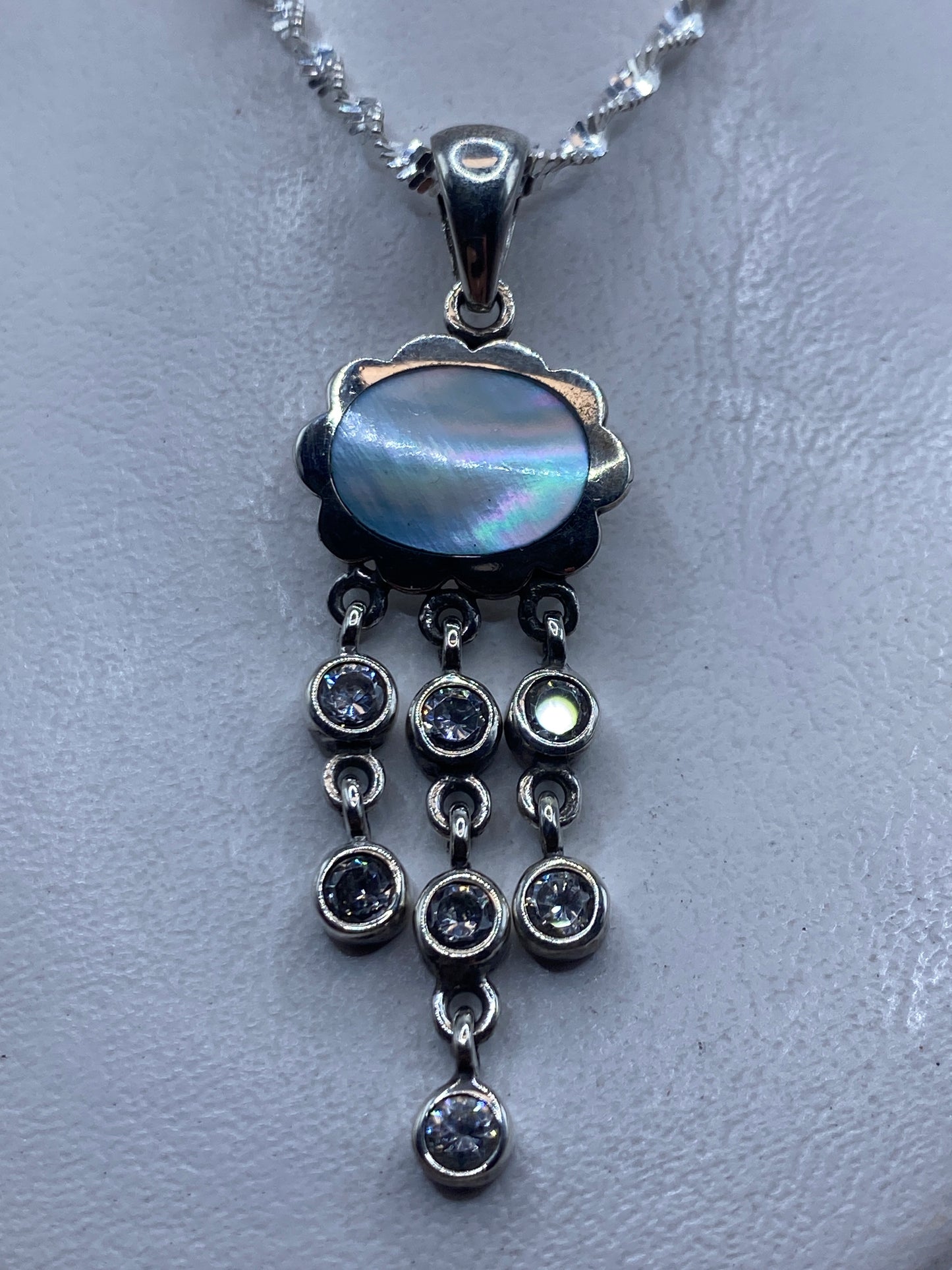 Dije de plata .925 con piedra azul cielo y cascada de circonias, colgado en collar plateado