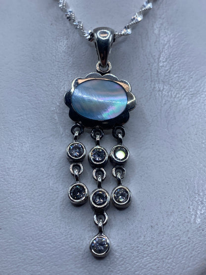 Dije de plata .925 con piedra azul cielo y cascada de circonias, colgado en collar plateado