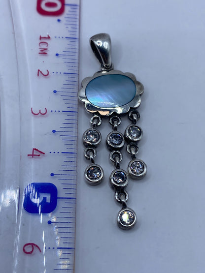 Dije de 5.6 cm de largo junto a regla de medición