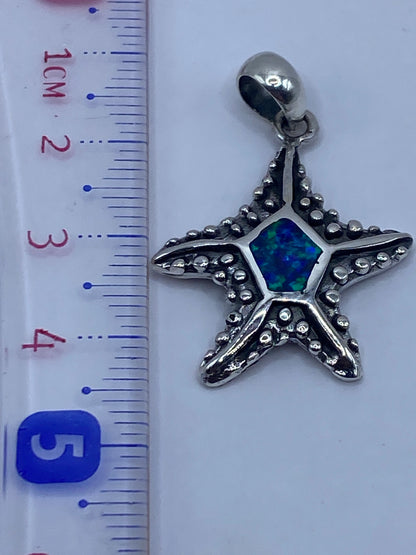 Dije de estrella marina junto a regla métrica mostrando tamaño de 4.5 cm