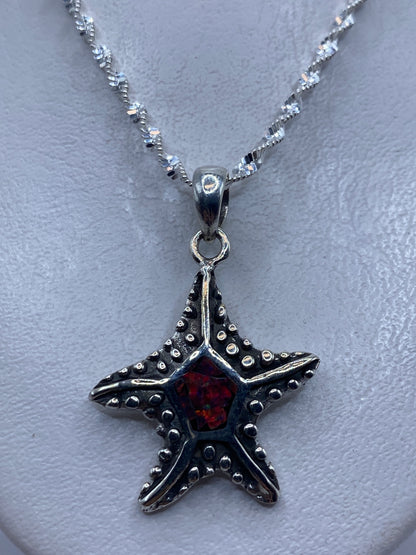 Dije estrella de mar de plata .950 con opalo de fuego multicolor en una cadena plateada