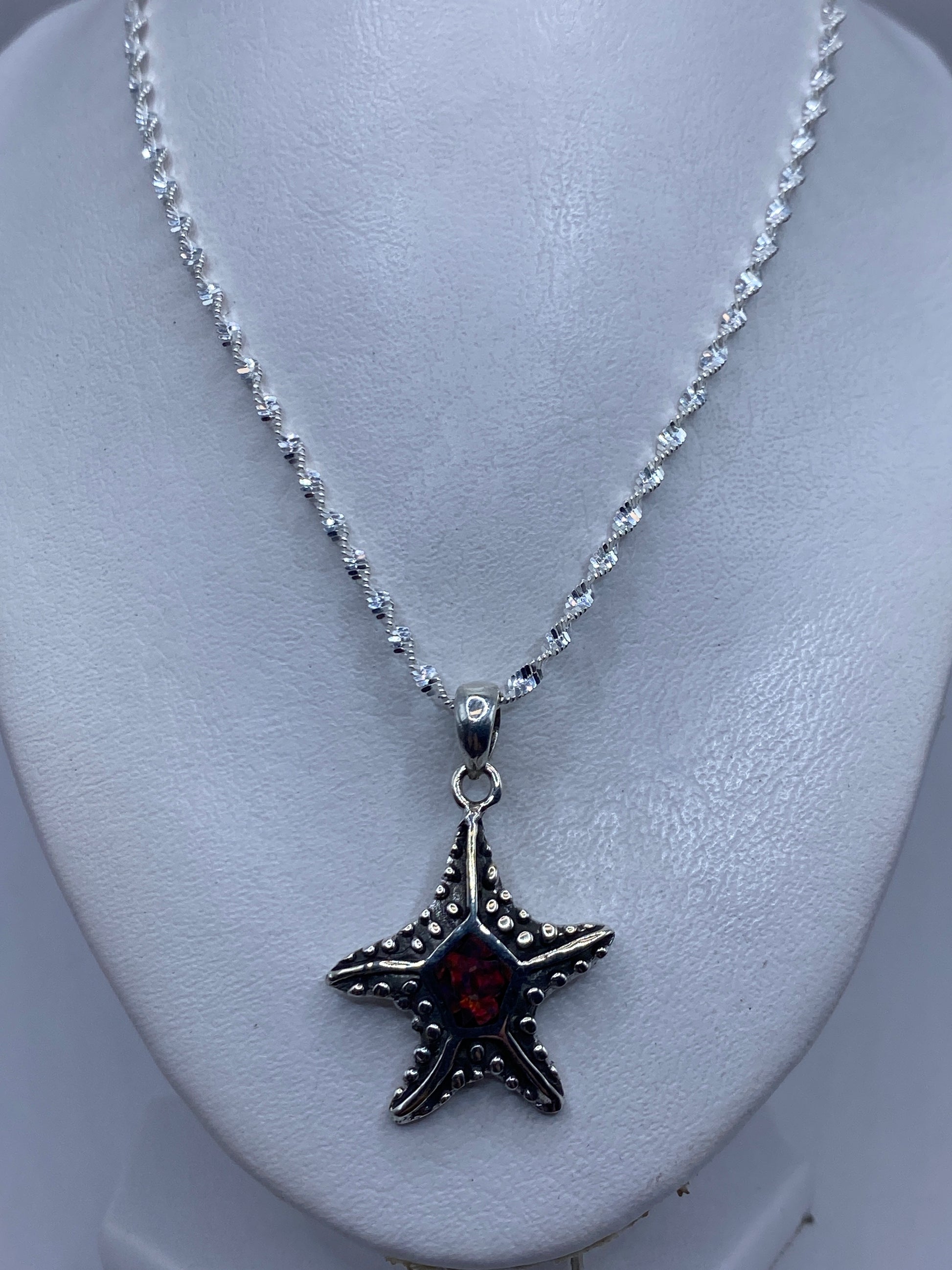 Detalle del reverso de la estrella de mar de plata con patrón de textura y el Quinto .950
