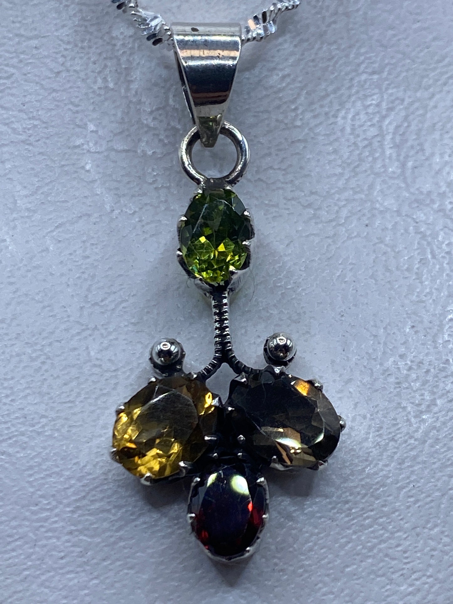 Dije de plata 4.9 cm con circonia multicolor amarilla, negra y roja engastado a mano, colgado en cadena de plata