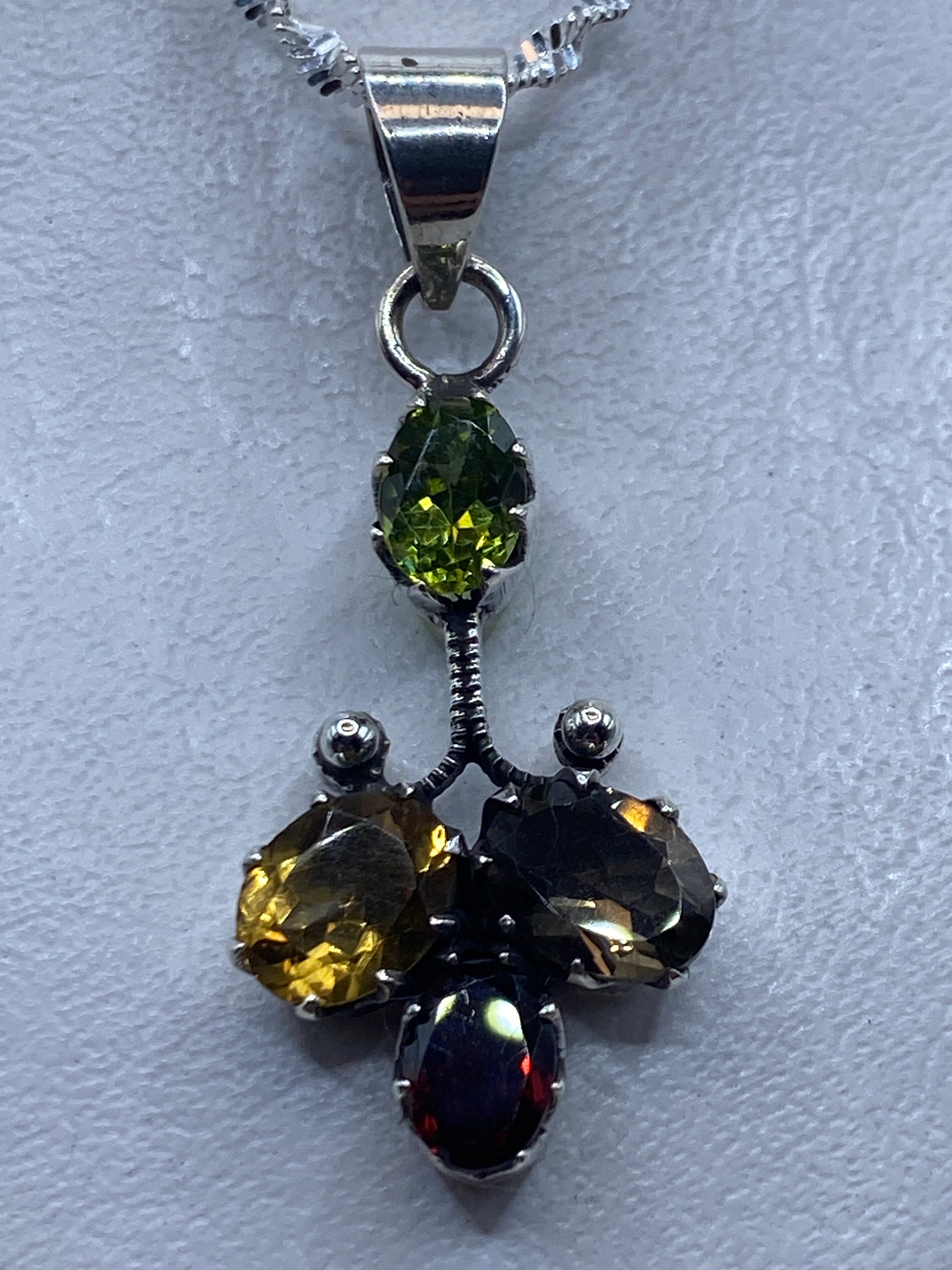 Dije de plata 4.9 cm con circonia multicolor amarilla, negra y roja engastado a mano, colgado en cadena de plata