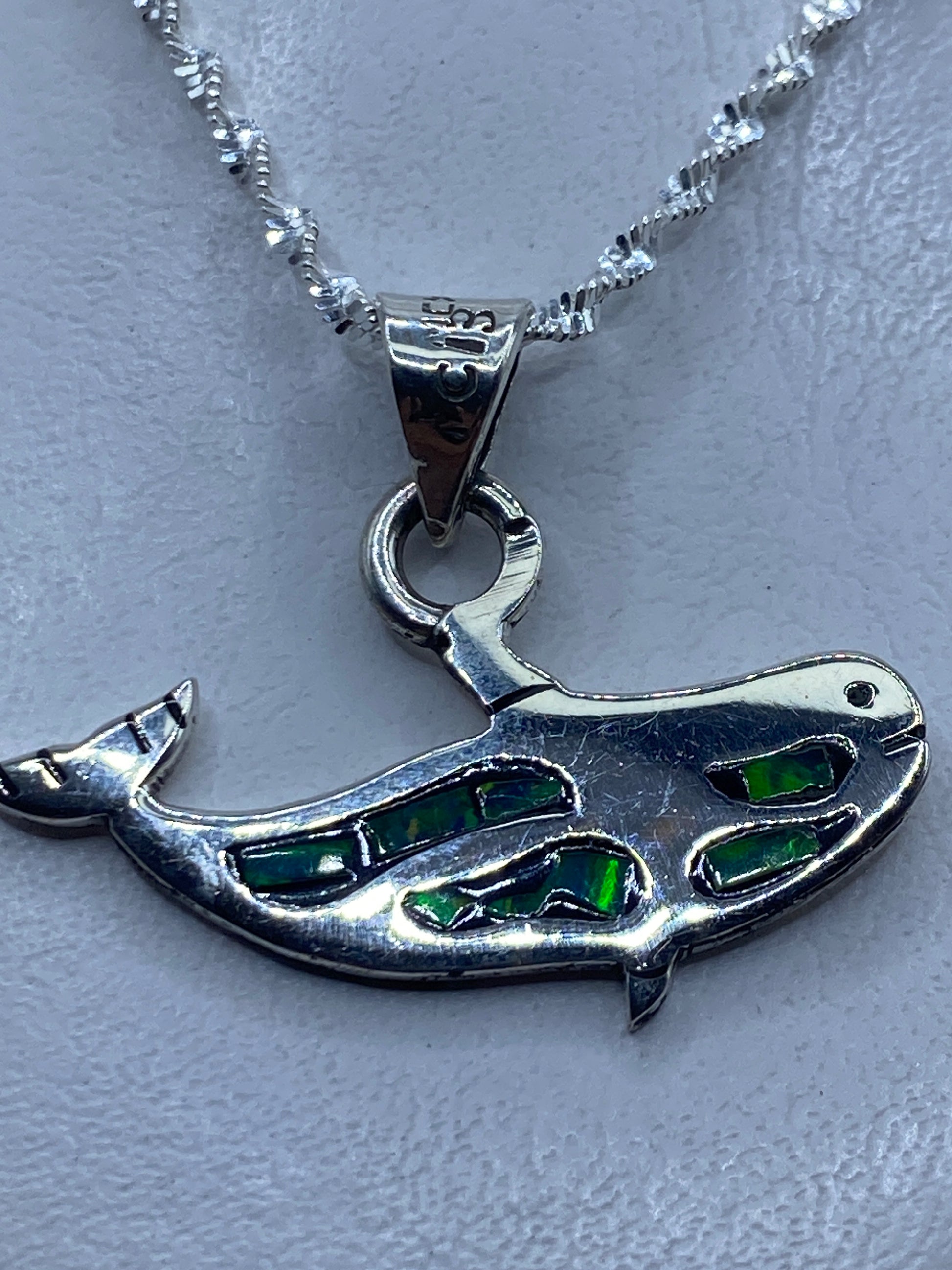 Dije de plata con ópalo de fuego verde engastado, colgando de cadena plateada