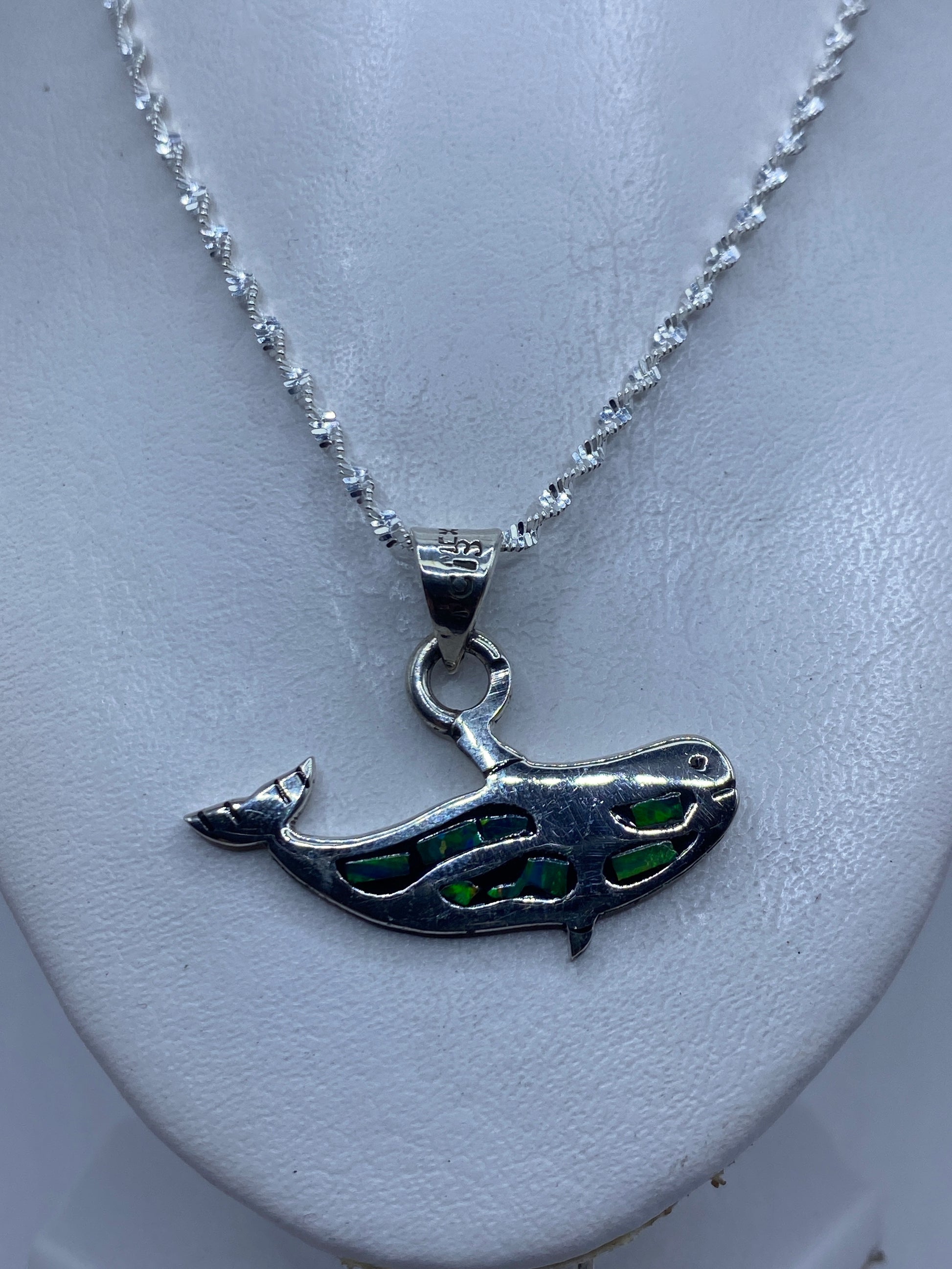 Dije de plata ópalo fuego mostrado sobre regla de medición: 3.7 cm de largo