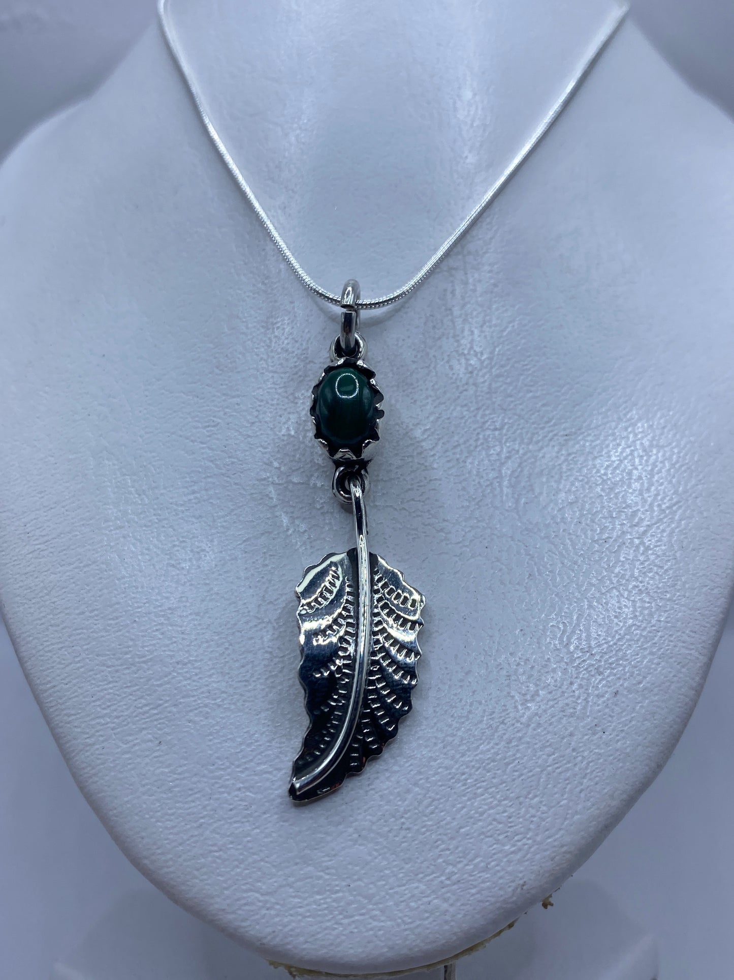 Detalle del engaste de malaquita en plata .925 y la talla de ala artesanal