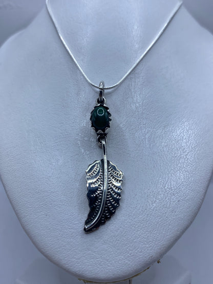 Detalle del engaste de malaquita en plata .925 y la talla de ala artesanal
