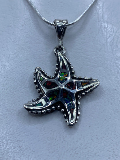 Dije estrella de mar con ópalo de fuego multicolor en plata .950, sobre cadena de serpiente