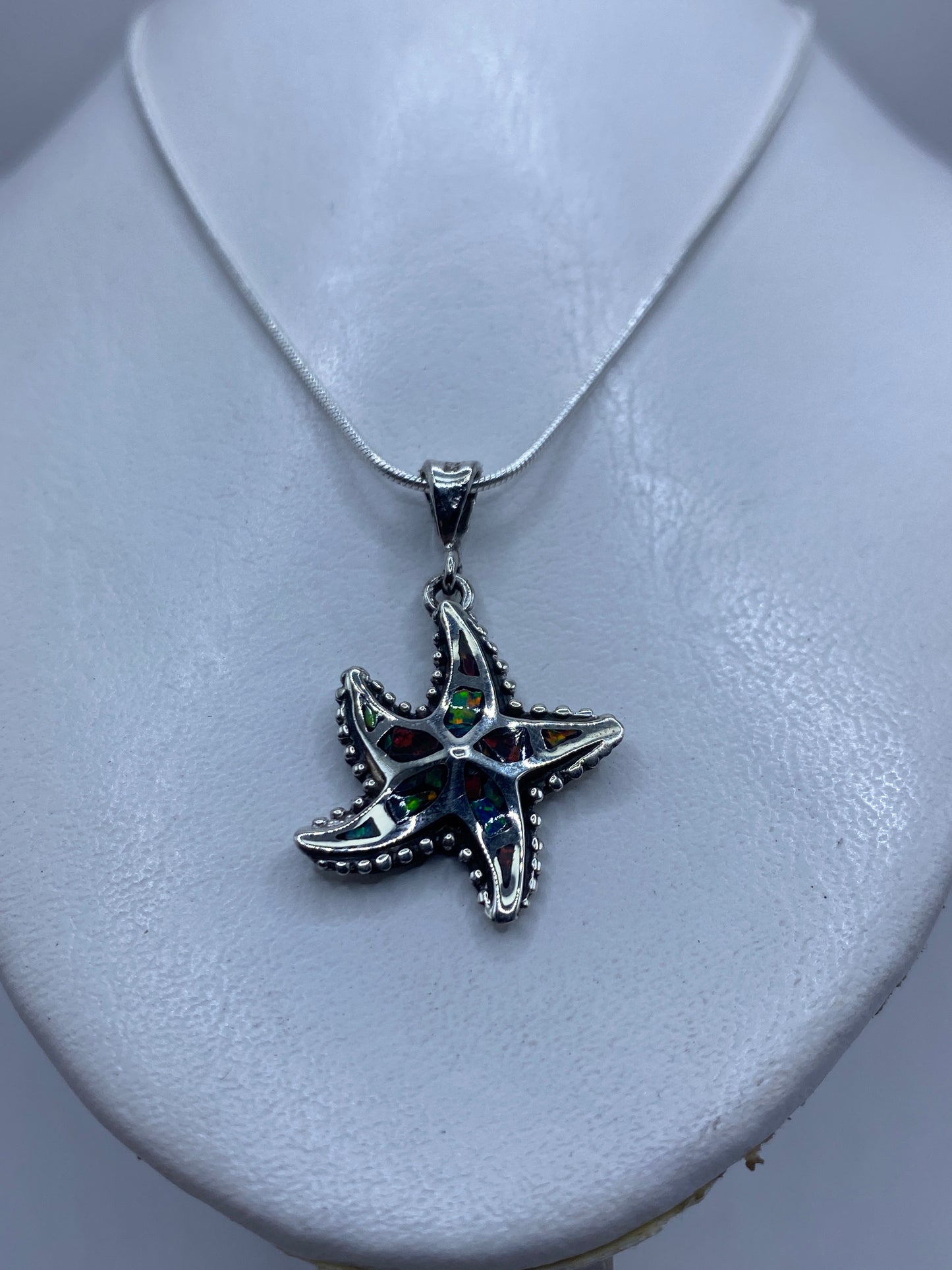 Detalle del ópalo de fuego mostrando los reflejos rojo, verde y naranja en la piedra engastada